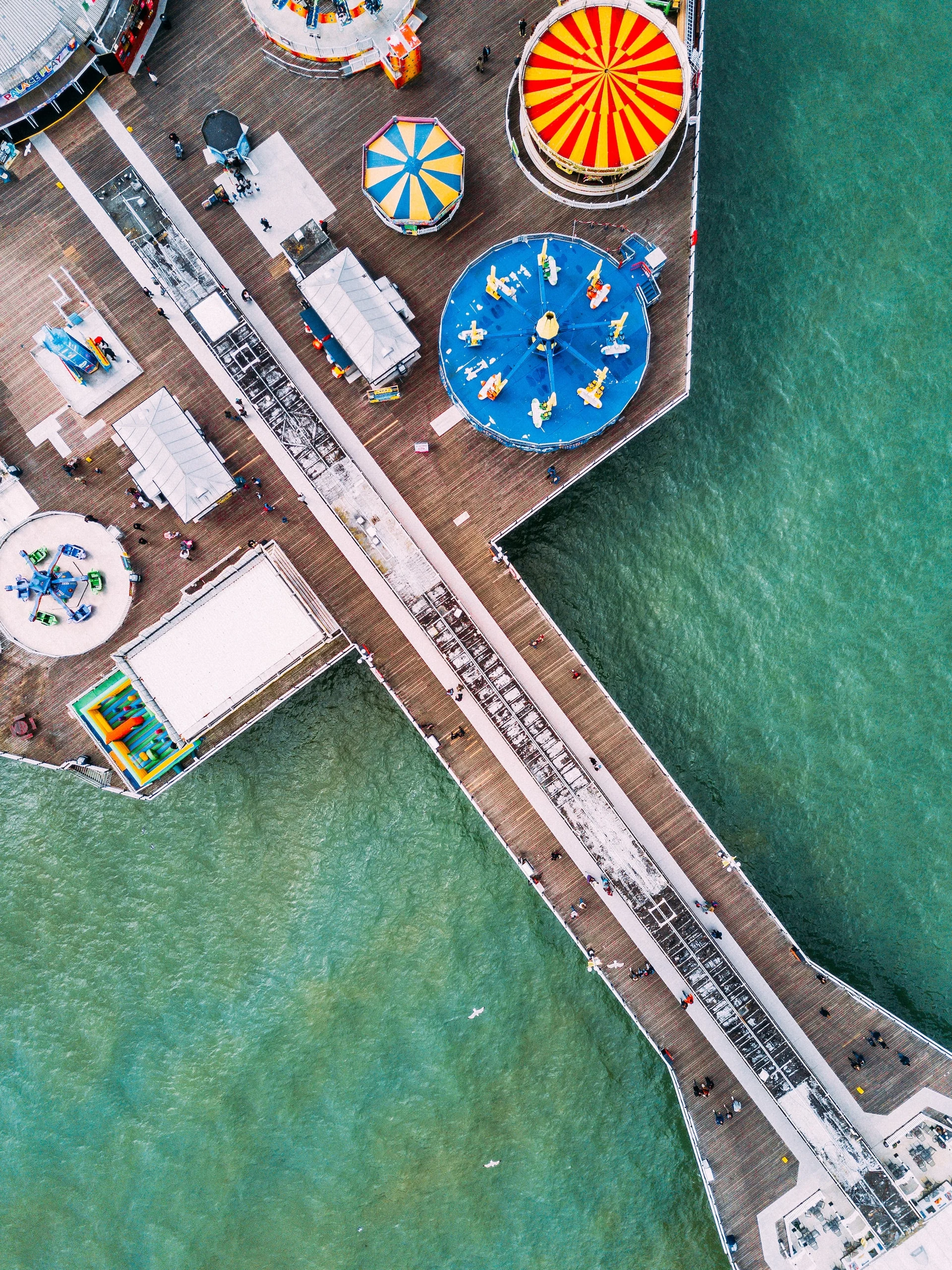 birds eye view on a pier with carousels and other attractions on it